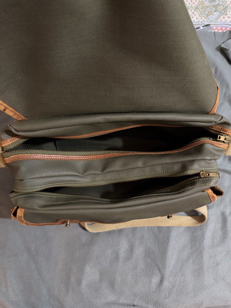 Porter laptop and messenger bag (Category: Sling Bags) located in Manila. Submitted by daleyo (Listing ID 1467292420, Image 2). Description: Pre loved item bought in Japan in 2019 Color - army green no scratches, no stitches Solid na leather ito. Can bring more items books, laptop, toiletrees etc. .