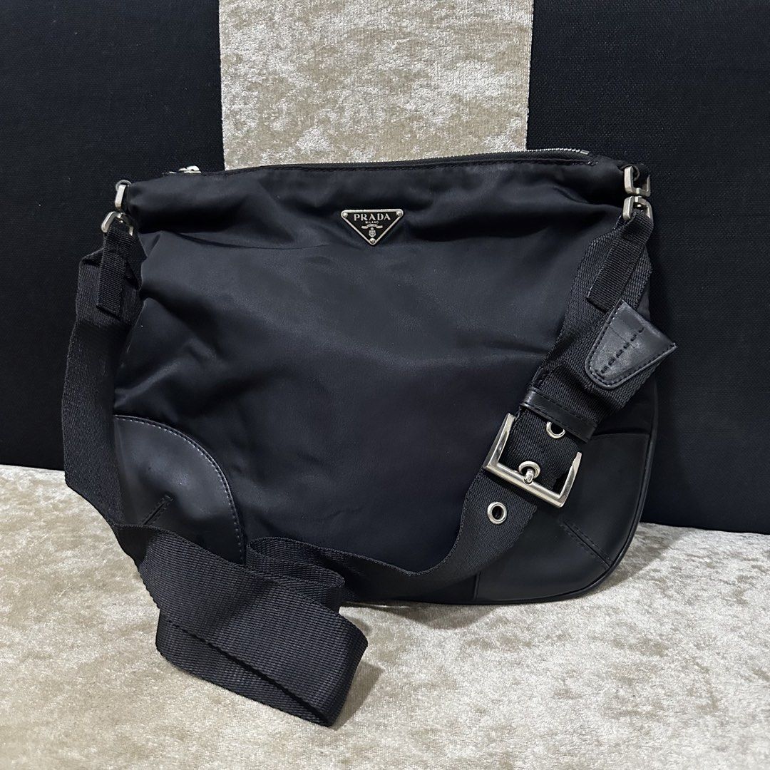 Prada Black Nylon Crossbody Bag (Category: Luxury Bags & Wallets) located in Quezon City. Submitted by retroboominwantsummoh (Listing ID 1467335168, Image 2). Description: - Authentic Prada crossbody bag - Durable black nylon material with leather corner reinforcements - Classic silver-tone metal hardware - Iconic triangular Prada metal logo plaque on the front - Secure zip top closure - Adjustable black fabric shoulder strap - Clean interior and