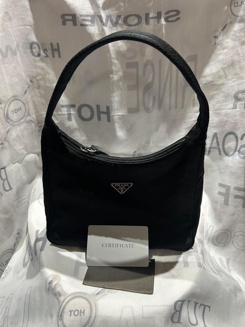 Prada Black Nylon Hobo Shoulder Bag (Category: Luxury Bags & Wallets) located in Manila. Submitted by mippolin (Listing ID 1465445865, Image 3). Description: - Authentic Prada black nylon hobo bag with silver-tone hardware and signature triangle logo - Versatile design featuring a top zipper closure and a clean black interior with a zip pocket - Comes with two interchangeable straps: a short fabric shoulder strap and an adjustable long crossbody 