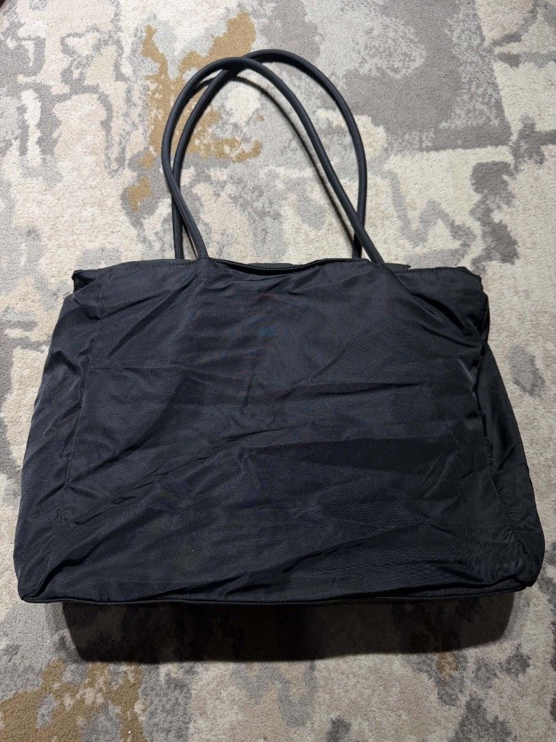 Prada Black Nylon Large Tote Bag (Category: Luxury Bags & Wallets) located in Dagupan City. Submitted by kiroshi12 (Listing ID 1467238432, Image 2). Description: - Authentic Prada black nylon tote bag - Iconic triangular logo plaque on the front - Double shoulder straps and secure top zip closure - Signature Prada jacquard lining with interior brand plaque - Features factory tag number 23 inside - Lightweight, spacious, and perfect for daily esse