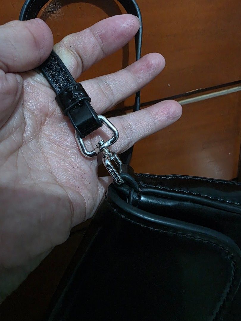 Prada Black Patent Leather Shoulder Bag (Category: Luxury Bags & Wallets) located in Lemery. Submitted by venus23 (Listing ID 1467191129, Image 3). Description: - Brand: Prada - Material: Black patent leather with glossy finish - Hardware & Logo: Silver-tone hardware with classic triangle logo plaque - Closure: Flap closure - Interior: Clean dark lining with enough room for daily essentials - Condition: Excellent/Classic piece.