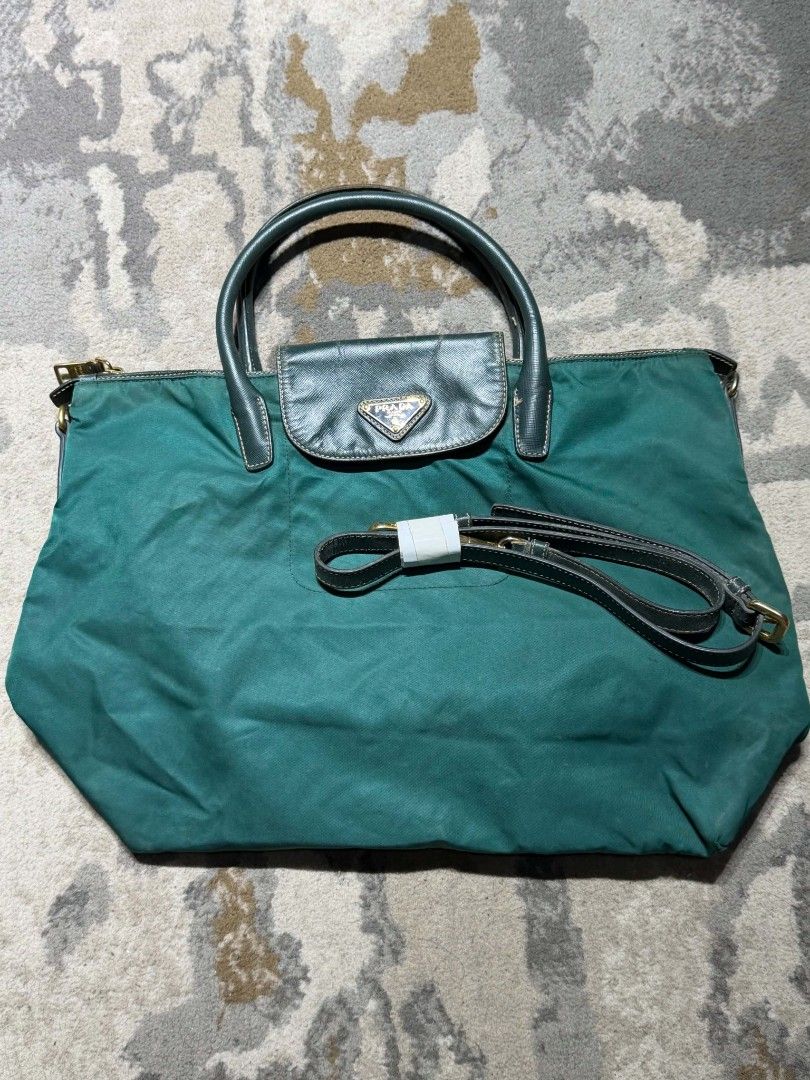 Prada Green Nylon with sling Tote Bag (Category: Luxury Bags & Wallets) located in Dagupan City. Submitted by kiroshi12 (Listing ID 1467238437, Image 2). Description: - Authentic Green Prada Tote Bag - Durable nylon material with chic leather handles - Front flap pocket featuring the iconic Prada triangle logo plaque - Premium gold-tone hardware and secure top zip closure with riri zipper - Includes a matching detachable shoulder strap (still wra