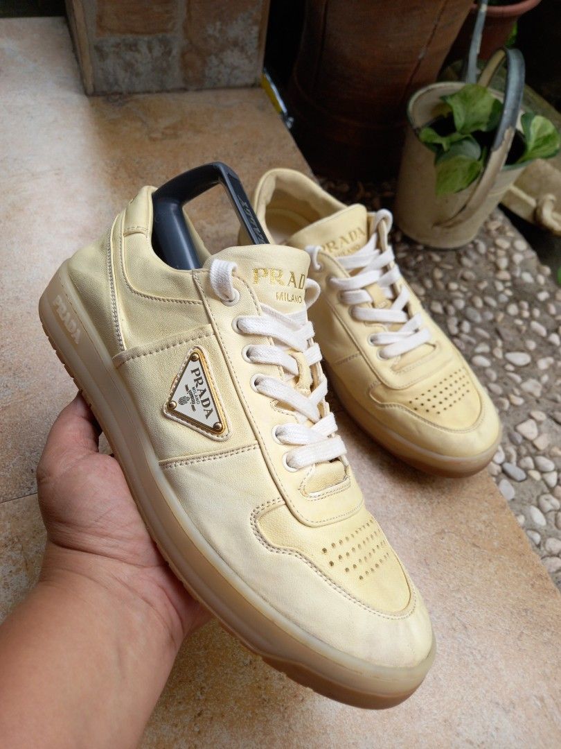 Prada Leather Sneakers Yellow (Category: Sneakers) located in Davao. Submitted by kirk214red-50020 (Listing ID 1467181967, Image 1). Description: - Brand: Prada - Color: Pale yellow with white laces - Material: Premium leather upper - Design: Low-top with perforated toe box and chunky translucent rubber sole - Branding: Iconic enamel triangle logo on the side and embossed lettering on the heel - Style: Luxury streetwear.