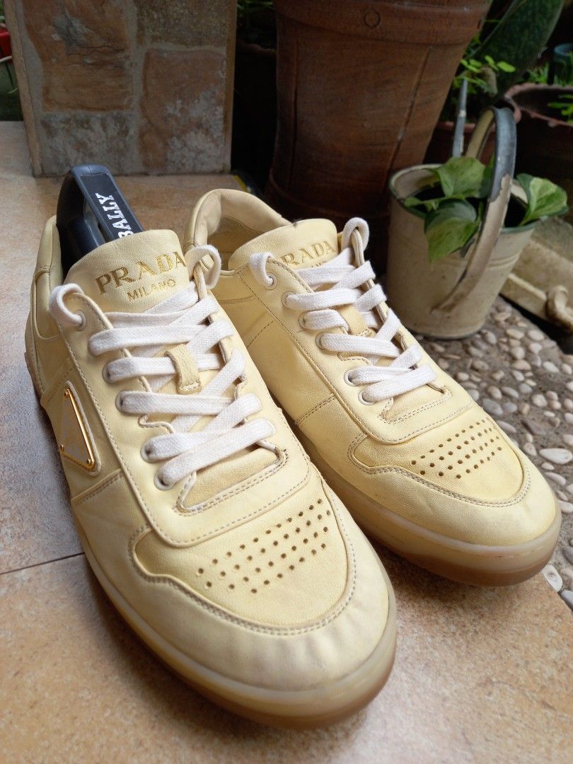 Prada Leather Sneakers Yellow (Category: Sneakers) located in Davao. Submitted by kirk214red-50020 (Listing ID 1467181967, Image 2). Description: - Brand: Prada - Color: Pale yellow with white laces - Material: Premium leather upper - Design: Low-top with perforated toe box and chunky translucent rubber sole - Branding: Iconic enamel triangle logo on the side and embossed lettering on the heel - Style: Luxury streetwear.