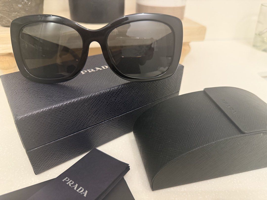 Prada SPR A08-F Black Sunglasses (Category: Sunglasses & Eyewear) located in Pasig City. Submitted by barbie527 (Listing ID 1467335892, Image 1). Description: - Brand: Prada - Model: SPR A08-F - Size: 57-18-145 - Color: Glossy black acetate - Style: Bold square frames with metal Prada lettering on temples - Inclusions: Original hard case, outer box, and paperwork booklets - Condition: Brand New Negotiable - Meet-ups or shipping available (Message