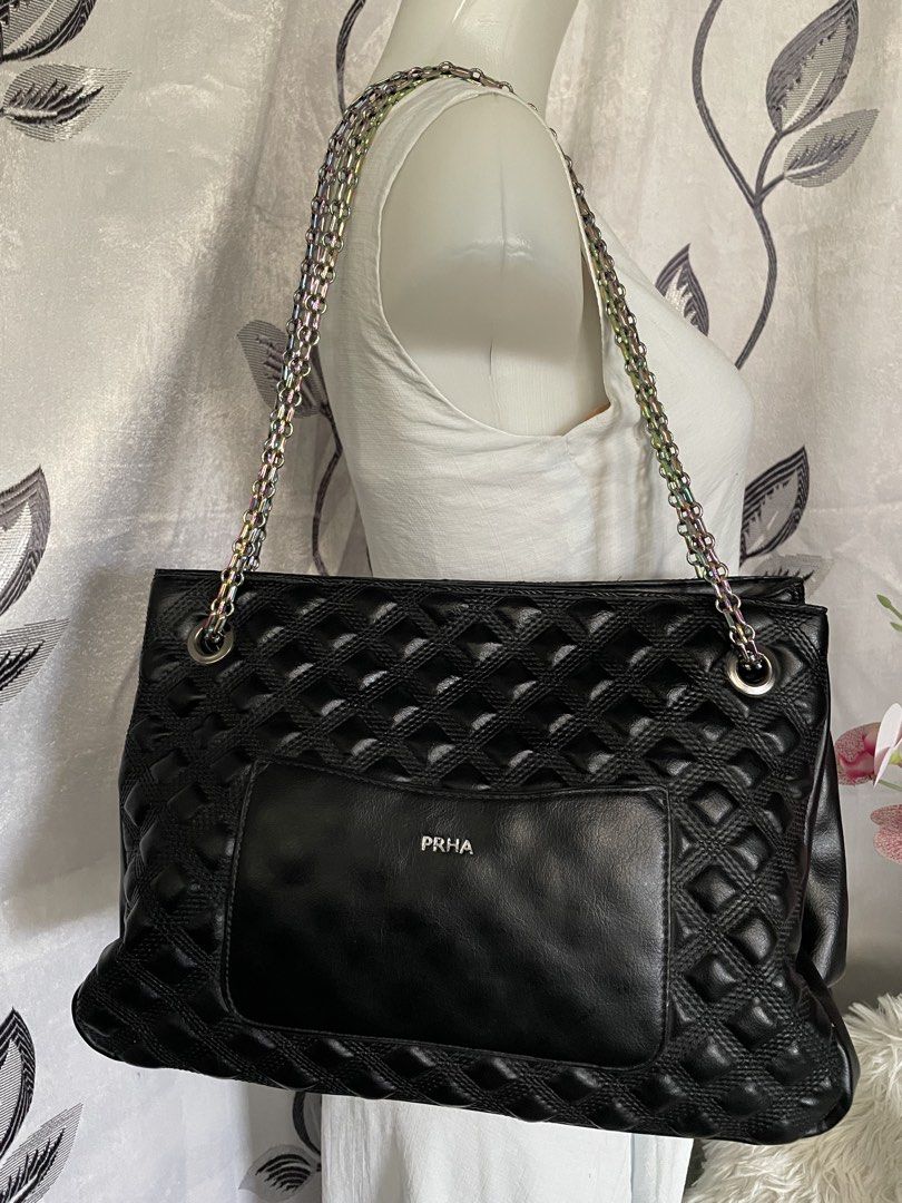 PRHA Black Quilted Shoulder Bag Rainbow Chain (Category: Shoulder Bags) located in Cabanatuan. Submitted by moraiahraven (Listing ID 1467257478, Image 3). Description: Stylish black quilted handbag with classic diamond-stitched pattern. Features dual metallic chain straps with a pretty iridescent/rainbow sheen, silver-tone hardware, and a front turn-lock clasp. Details: • Exterior: Soft black quilted material with diamond pattern • Straps: Double