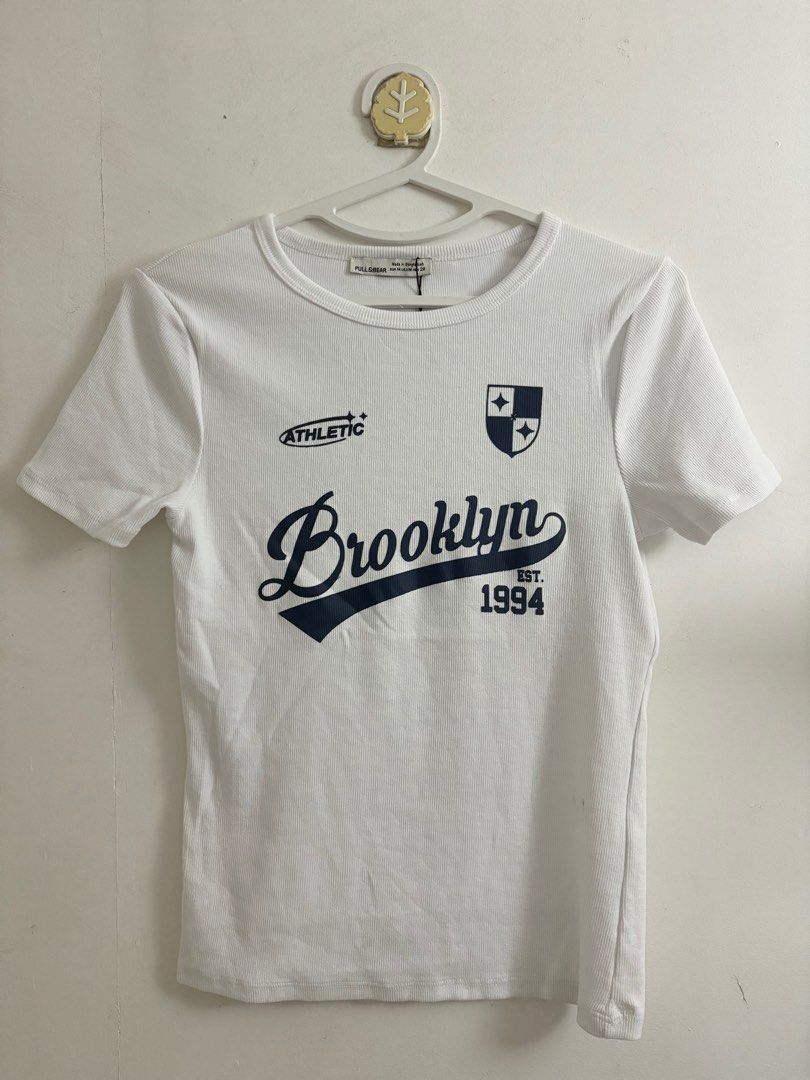 Pull&Bear White Brooklyn 1994 Ribbed T-Shirt (Category: Shirts) located in Quezon City. Submitted by geminiselection (Listing ID 1467344951, Image 1). Description: - pull and bear - brandnew - S- semi large, very stretchy.