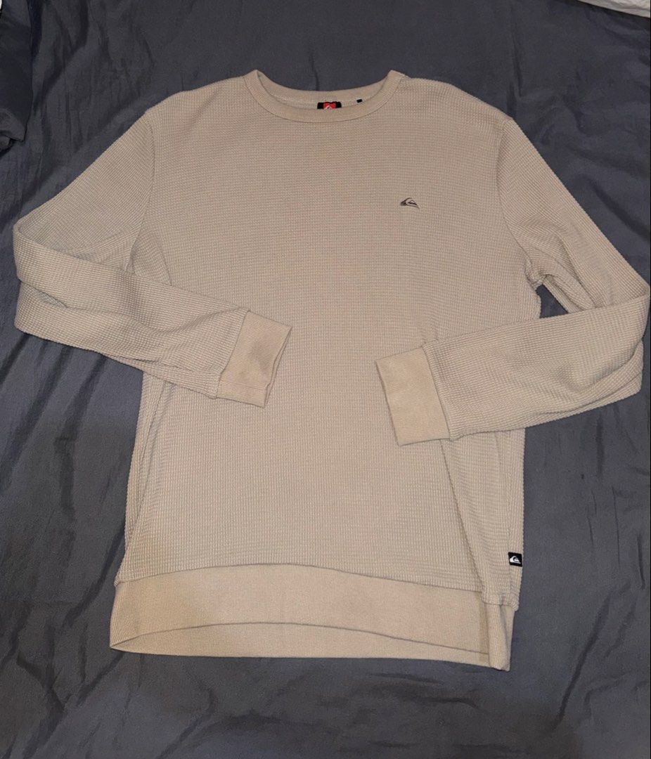Quiksilver Waffle Knit Long Sleeve Sweater Medium (Category: Coats, Jackets and Outerwear) located in Andop. Submitted by nobleangel (Listing ID 1467310336, Image 1). Description: - Brand: Quiksilver - Color: Beige - Size: Medium - Material: Soft waffle knit textured fabric - Design: Crew neck with ribbed cuffs and hem - Details: Small embroidered mountain logo on the chest and branded tag near the lower hem - Condition/Use: Comfortable everyday 