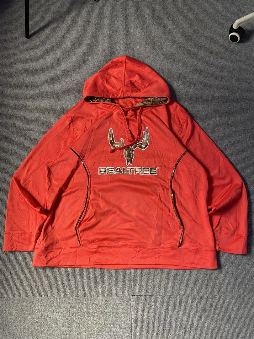 Realtree pink Camo Accent Pullover Hoodie (Category: Coats, Jackets and Outerwear) located in Maria Aurora. Submitted by mightypenguin.f7ca53 (Listing ID 1467272794, Image 1). Description: - Brand: Realtree - Color: Bright orange with camo accents - Design: Embroidered antler logo on chest, camo hood lining and pocket trims - Features: Adjustable drawstrings, front kangaroo pocket - Material: Soft fabric construction.