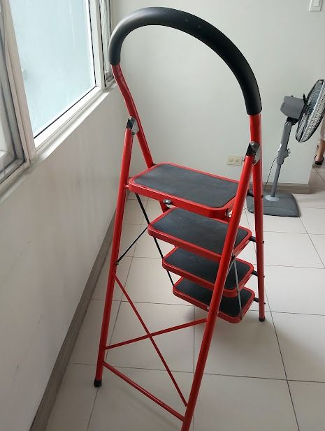 Red 4-Step Folding Ladder With Handrail (Category: Ladders & Steps) located in Quezon City. Submitted by susmaryosep1 (Listing ID 1467268663, Image 3). Description: - Bright red 4-step folding ladder, ideal for household chores and reaching high spots - Textured black treads on every step for a secure, anti-slip grip - Curved top handle with comfortable foam grip for added stability and easy carrying - Sturdy metal frame folds completely flat for
