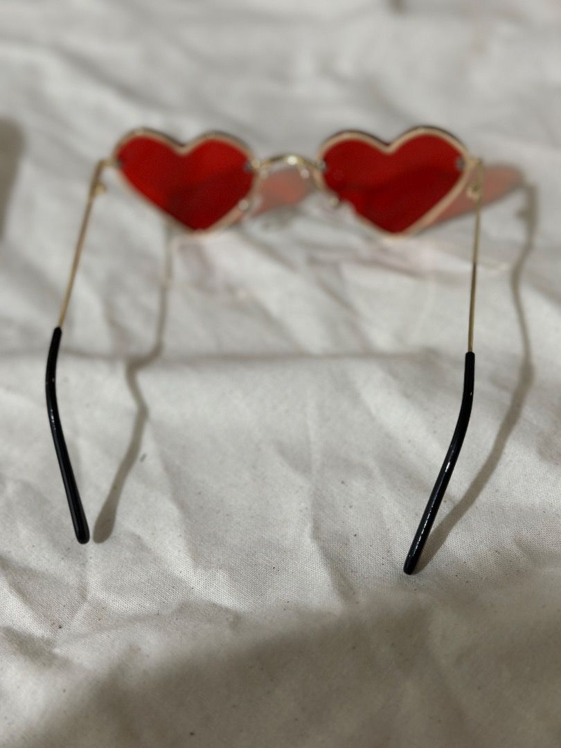 Red heart-shaped sunglasses with gold frame (Category: Babies & Kids Fashion) located in Mandaluyong City. Submitted by lovedbyjaaaam (Listing ID 1467284201, Image 3). Description: - Trendy red heart-shaped lenses with a stylish gold-tone wire frame - Comfortable black temple tips for all-day wear - Lightweight design with a clear red tint - Pristine condition: zero scratches on the lenses - Fun accessory for parties, festivals, or casual outdoor