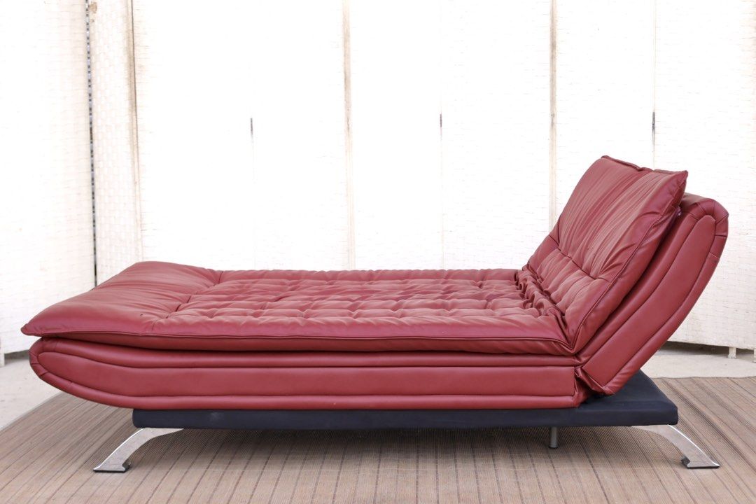 Red leather sofa bed convertible futon with chrome legs (Category: Sofas) located in Bulacan. Submitted by FurnitureGallery (Listing ID 1467302934, Image 3). Description: - Red faux leather futon sofa bed - Easily converts flat for sleeping or lounging - Comfortable tufted cushions on seat and backrest - Sleek shiny chrome metal legs - Sturdy solid frame underneath - Condition note: Has scuff marks and a small tear on the corner upholstery near t