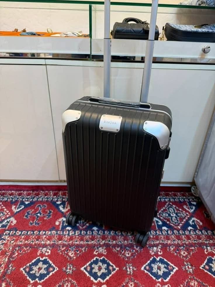 R-MOWA-- suitcase hard shell trolley with wheels and handle (Category: Luggage) located in Manila. Submitted by dh3nz1 (Listing ID 1467175596, Image 1). Description: - Color: Clean black finish - Design: Iconic vertical ribbed hard shell with front branded badge - Mobility: Smooth-gliding 4-spinner wheels - Handle: Fully functional telescopic pull handle - Protection: Durable metal corner guards - Size: Ideal for weekend trips and cabin baggage.
