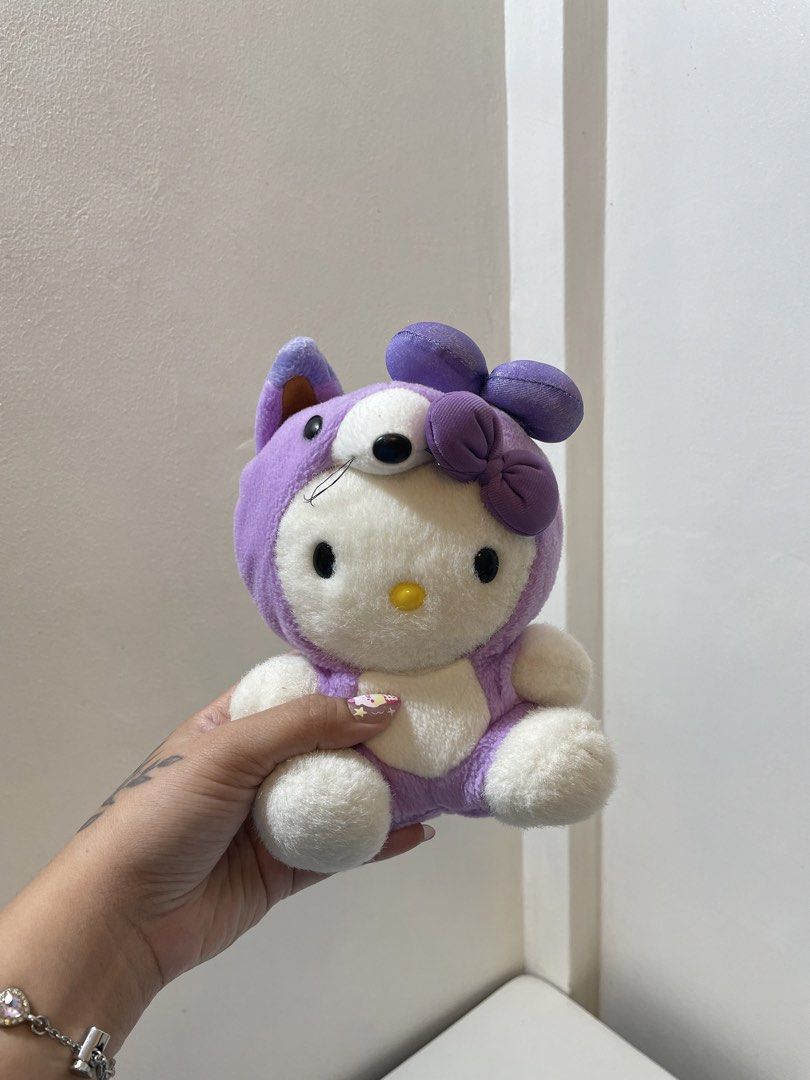 Sanrio Hello Kitty Lavender Fox Costume Plush (Category: Plushies & Soft Toys) located in Iba. Submitted by wealtheallymari99 (Listing ID 1467268544, Image 1). Description: - Character: Kitty in a cute purple fox costume - Details: Features a matching lavender bow and ' Kitty Lavender' tag on the back - Size/Pose: Roughly sitting position - Condition: Clean, soft, and in great shape - Ideal for: Sanrio fans and plushie collectors.