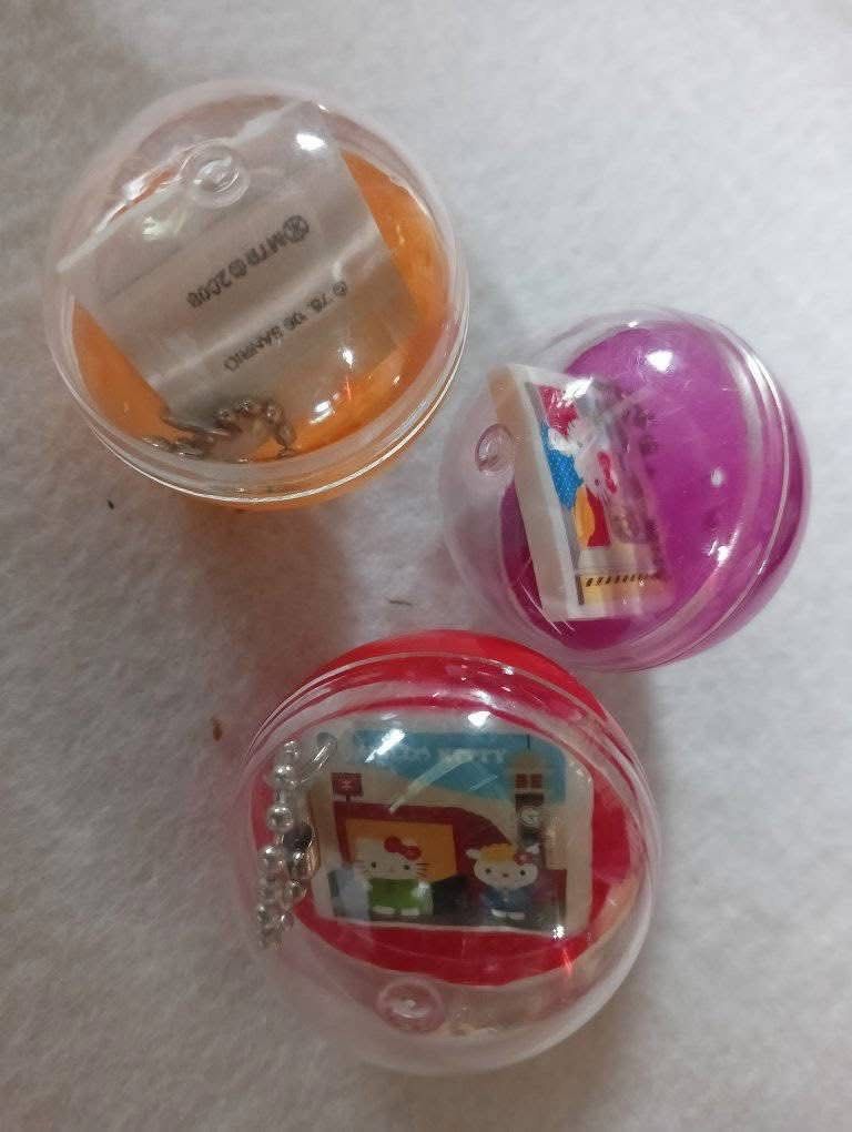 Sanrio Hello Kitty MTR 2008 Keychain Set (Category: Character Goods) located in Manila. Submitted by janetecson05 (Listing ID 1467309700, Image 1). Description: - Set of 3 rare Kitty MTR keychains from 2008 - Features different MTR station scenes with Kitty and friends on each square tile - Includes original gachapon capsules in orange, purple, and red - Comes with attached silver ball chains - Stamped with © 76, 06 SANRIO and © MTR © 2008 on the