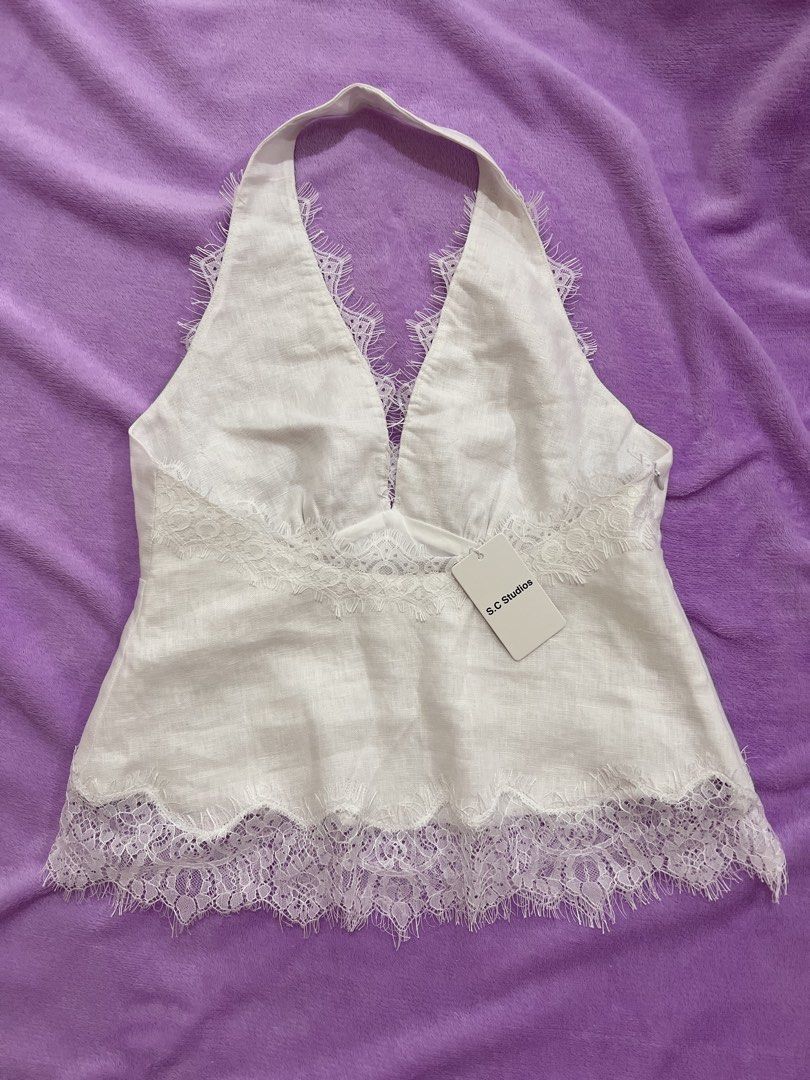 SC Studios Madelyn Lace Linen Top (Category: Sleeveless) located in Caloocan City. Submitted by jclosetsale (Listing ID 1467193147, Image 2). Description: - Brand: S.C Studios - Condition: Brand new with tag attached - Material: White linen - Style: Halter top with open back design - Details: Delicate eyelash lace trim along the V-neckline and bottom hem.