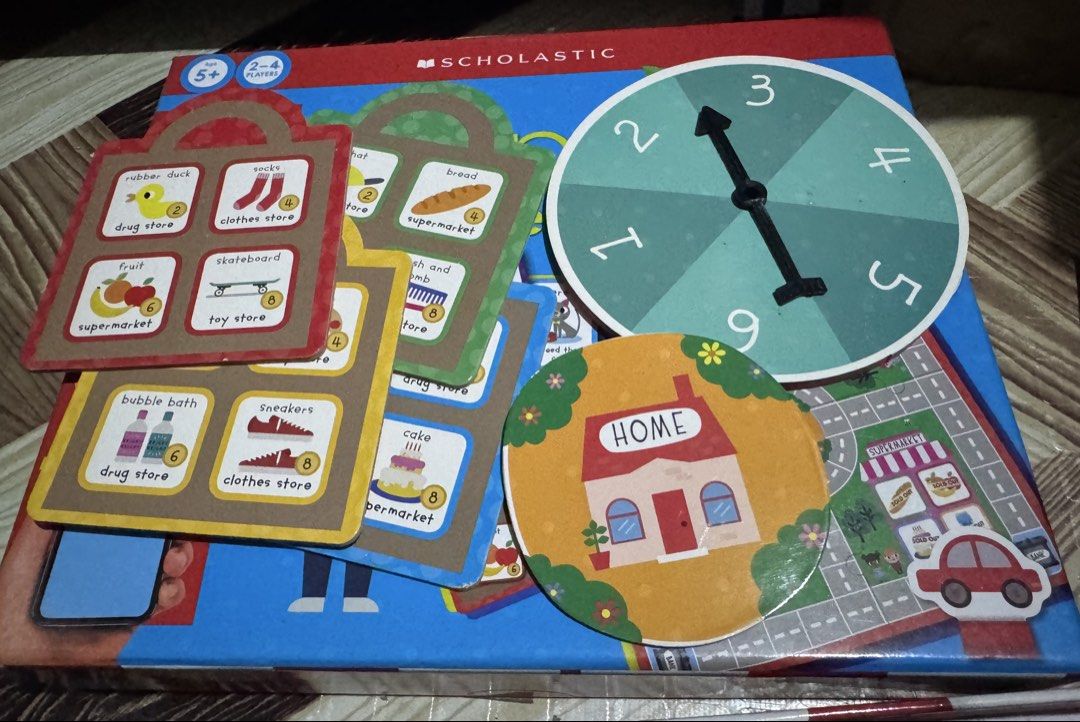 Scholastic The Shopping Game Educational Board Game (Category: Board Games & Puzzles) located in San Pedro. Submitted by pageturner19 (Listing ID 1467177051, Image 2). Description: - Scholastic kids board game, ideal for ages 5 and up - For 2 to 4 players, great for family game night - Fun way to practice counting, money values, and problem-solving - Complete set: double-sided board, car pieces, spinner, shopping bags, item cards, chore cards, ba