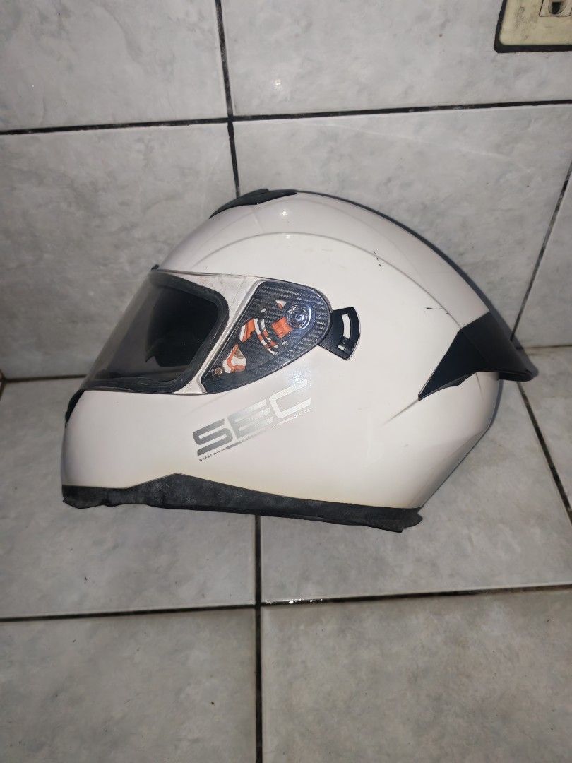 SEC White Full Face Motorcycle Helmet with Bag (Category: Bicycles) located in Iriga City. Submitted by aldwinpawl (Listing ID 1467176745, Image 1). Description: - Brand: SEC - Type: Full face motorcycle helmet - Color: White with aerodynamic rear spoiler - Visor: Dark tinted visor installed - Inclusions: Original black SEC branded storage bag with red logo - Condition: Decent everyday riding helmet, ready for pick up or shipping.