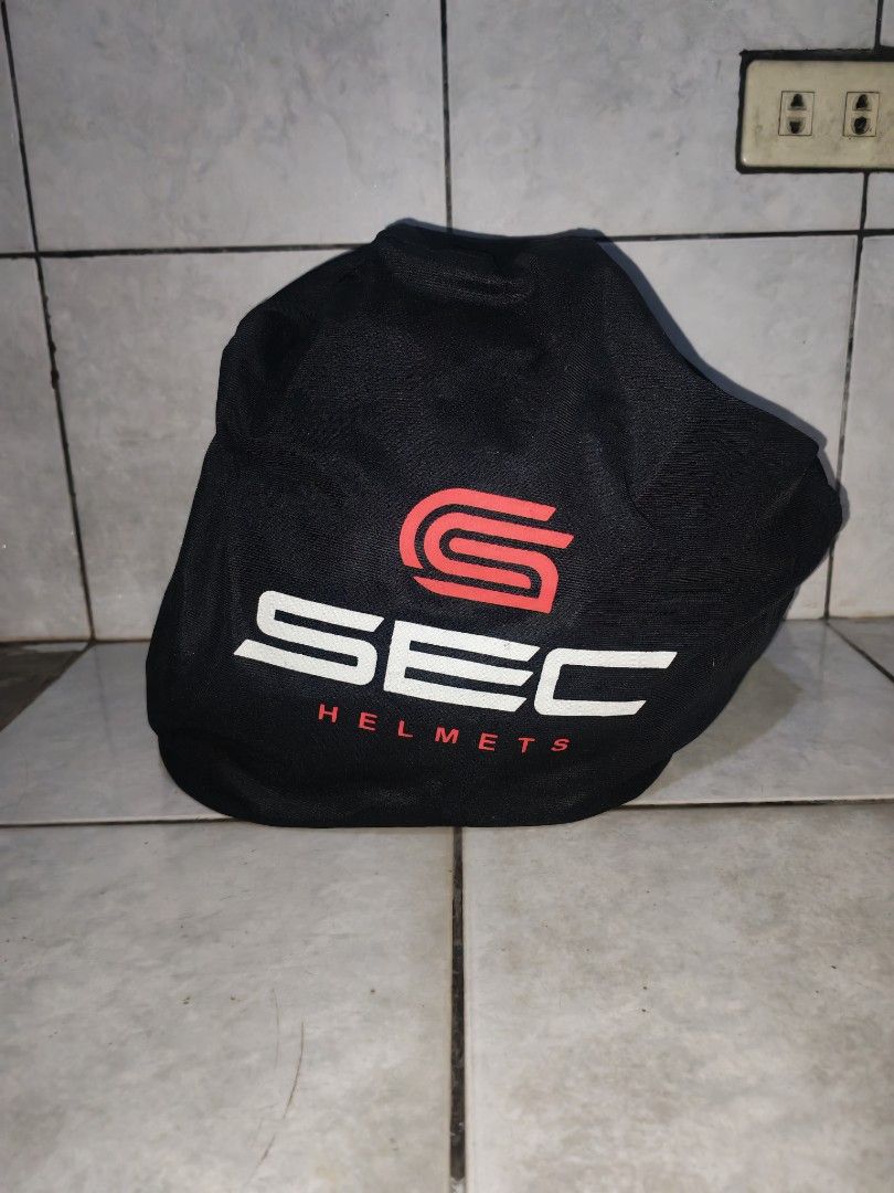 SEC White Full Face Motorcycle Helmet with Bag (Category: Bicycles) located in Iriga City. Submitted by aldwinpawl (Listing ID 1467176745, Image 2). Description: - Brand: SEC - Type: Full face motorcycle helmet - Color: White with aerodynamic rear spoiler - Visor: Dark tinted visor installed - Inclusions: Original black SEC branded storage bag with red logo - Condition: Decent everyday riding helmet, ready for pick up or shipping.