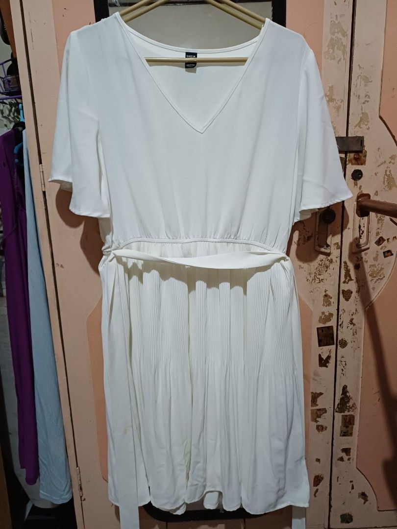 SHEIN White Pleated Dress Size L (Category: Dresses) located in San Pedro. Submitted by purpledream0316 (Listing ID 1467319313, Image 1). Description: - Brand: SHEIN - Style: White midi dress with V-neck and short sleeves - Features: Pleated skirt section and matching fabric waist tie - Size: L (EU 40/42, US 8/10) - Condition: Clean, solid white fabric, ready to wear.