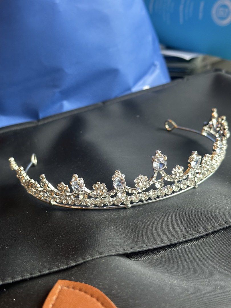 Silver Rhinestone Tiara Crown Hair Accessory (Category: Hair Accessories) located in Taguig. Submitted by ellajanee (Listing ID 1467233940, Image 2). Description: - Stunning silver tiara covered in sparkling rhinestones and faux crystals - Features intricate floral and scroll patterns for an elegant look - Curved metal band with end loops for secure hair pinning - Lightweight and comfortable for all-day wear - Ideal for parties, proms, weddings, 