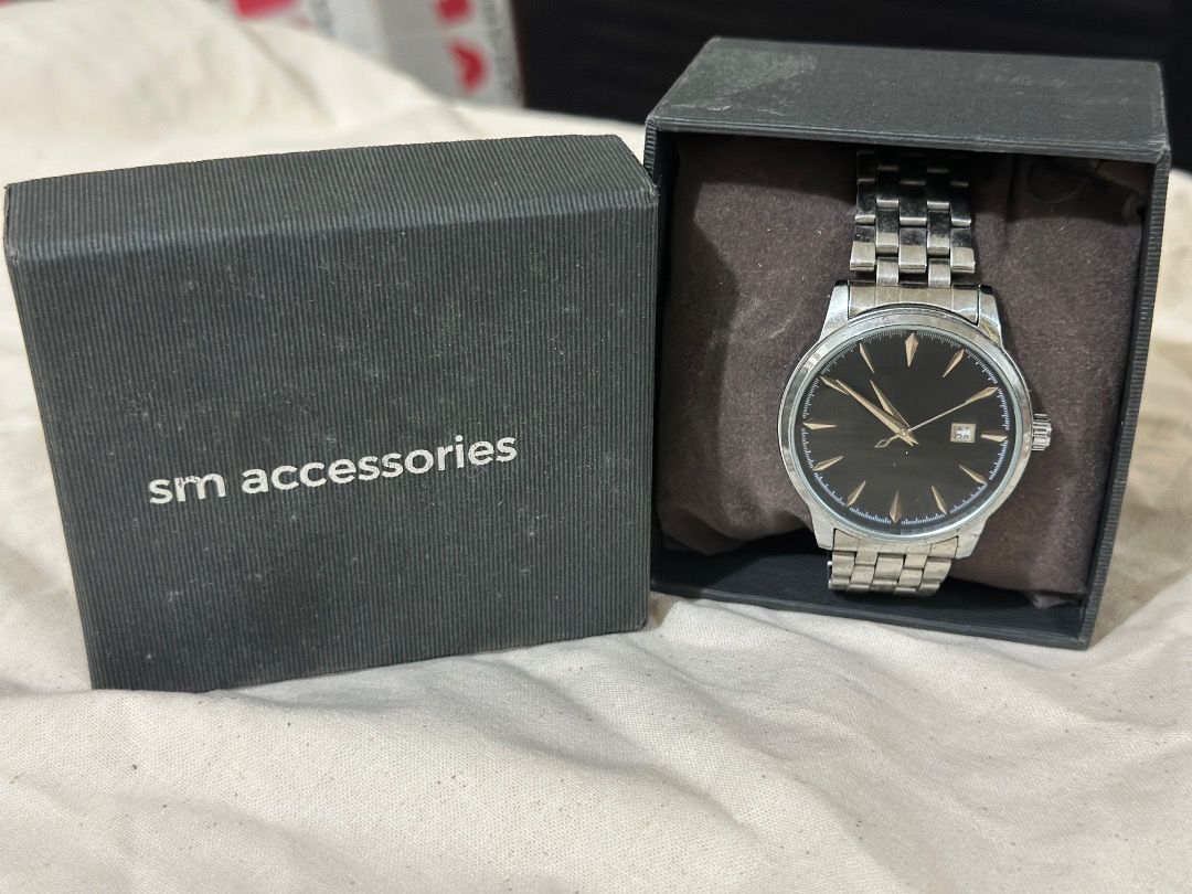 Silver wristwatch with black sunburst dial (Category: Men's Watches) located in Mandaluyong City. Submitted by lovedbyjaaaam (Listing ID 1467278002, Image 2). Description: - Stainless steel wristwatch with a polished silver-tone finish - Textured black sunburst dial with elegant gold-tone hands and hour markers - Convenient date window near the top of the dial - Multi-link metal bracelet with a secure deployant clasp - Clean crystal with minimal,