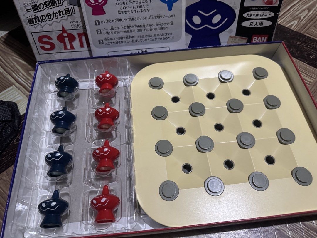 Simpei! Bandai 2-Player Strategy Board Game (Category: Board Games & Puzzles) located in San Pedro. Submitted by pageturner19 (Listing ID 1467176413, Image 2). Description: - Rare 2005 Bandai Japanese strategic board game - 2-player battle format using red and blue pieces on a multi-layered board - Objective: Line up three pieces in a row to win - Complete set: Includes original box, game board, red/blue pieces, and instruction manual - Condition