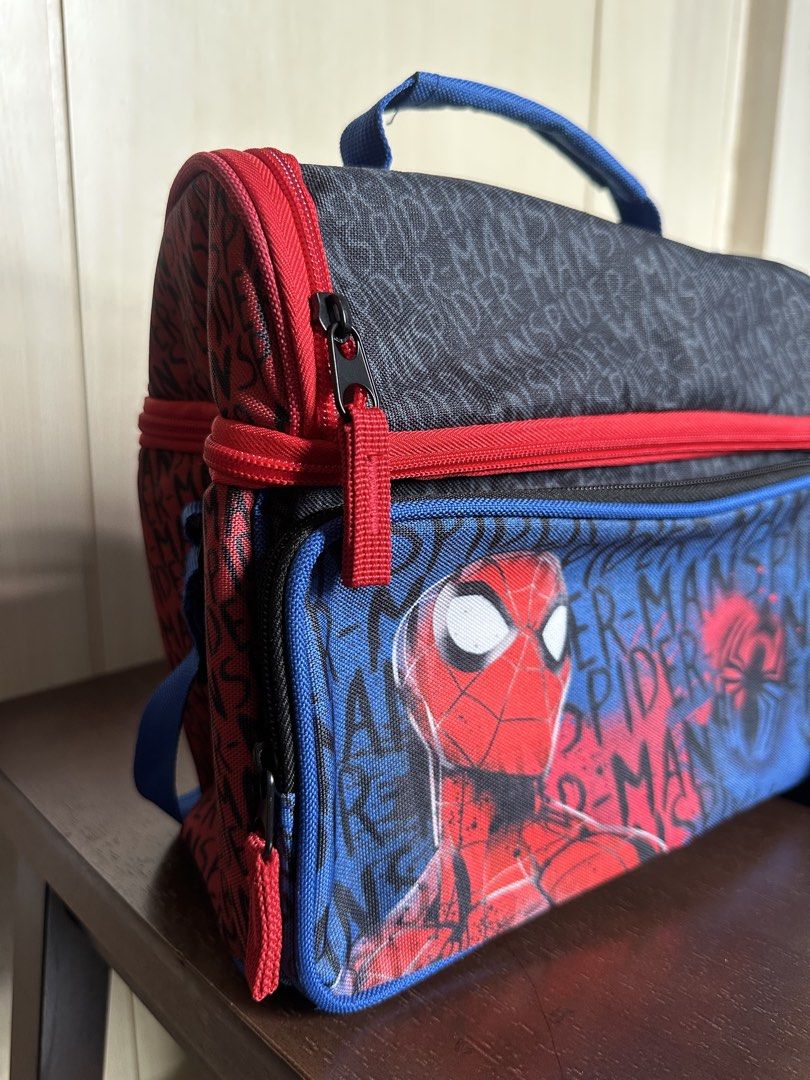 Spider-Man Double Compartment Insulated Lunch Bag (Category: Tote Bags) located in Quezon City. Submitted by ys4bella (Listing ID 1467175653, Image 3). Description: - Official Spider-Man design featuring bold graphics and a cool red, blue, and black color scheme - Dual compartments with sturdy red zippers to keep food organized - Insulated silver lining inside to keep meals hot or cold for hours - Extra zippered front pocket for small utensils, n