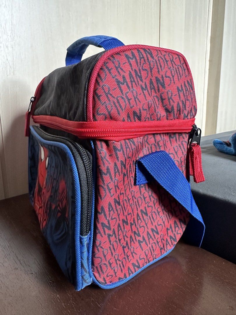 Spider-Man Double Compartment Insulated Lunch Bag (Category: Tote Bags) located in Quezon City. Submitted by ys4bella (Listing ID 1467175653, Image 2). Description: - Official Spider-Man design featuring bold graphics and a cool red, blue, and black color scheme - Dual compartments with sturdy red zippers to keep food organized - Insulated silver lining inside to keep meals hot or cold for hours - Extra zippered front pocket for small utensils, n
