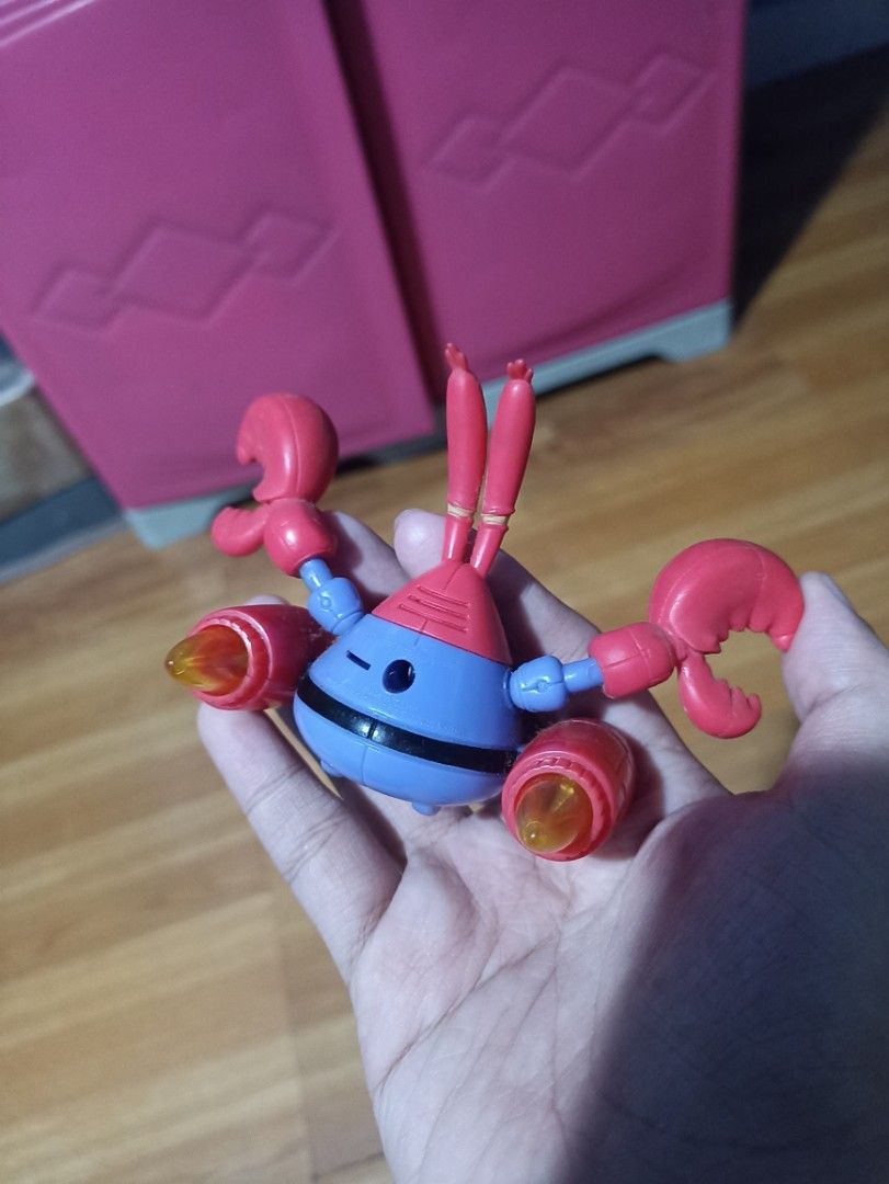 SpongeBob SquarePants Mr. Krabs Action Figure Toy (Category: Figurines & Statues) located in Manila. Submitted by hobbymo_koleksyon.ph (Listing ID 1467315438, Image 2). Description: - Character: Mr. Krabs from SpongeBob SquarePants - Outfit: Blue uniform with a black belt and yellow dollar sign buckle - Features: Dual mechanical crab claws and side rocket boosters with yellow flame details - Articulation: Movable arms and joints for posing - Cond