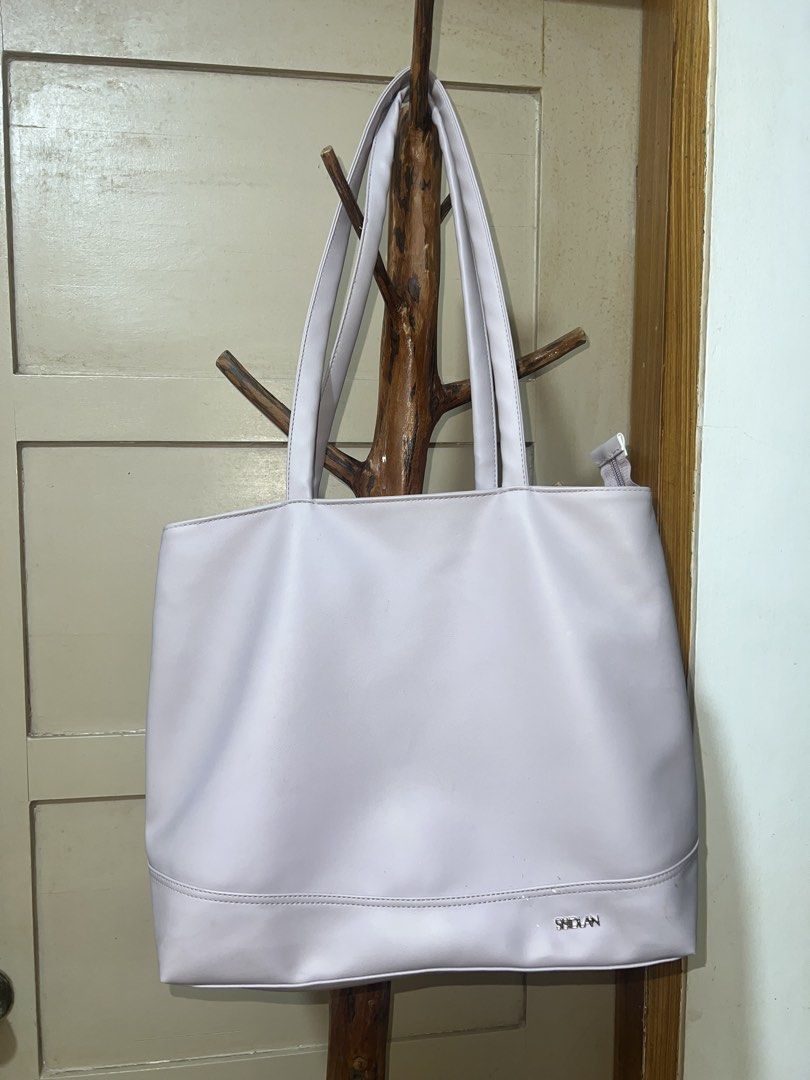 SSIDLAN Light Purple Tote Bag (Category: Tote Bags) located in Manila. Submitted by goldenwater_a772ad (Listing ID 1467195369, Image 2). Description: - Brand: SSIDLAN - Color: Light purple / Solid - Material: Faux leather - Features: Spacious interior, secure zipper closure, comfortable shoulder straps, silver-toned brand lettering - Condition: Minor scuffs and marks on the lower front near the logo - Perfect for: Work, school, or casual daily us