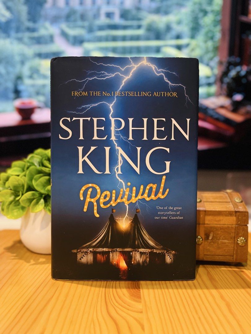 Stephen King Revival Hardcover Novel (Category: Storybooks) located in Makati City. Submitted by pagesandplay (Listing ID 1467319246, Image 1). Description: - Title: Revival by Stephen King - Format: Hardcover edition by Hodder & Stoughton - Cover Design: Dark blue with striking lightning and tent illustration - Condition: Spine, pages, and edges are clean and fully intact - Genre: Perfect for horror and suspense fiction lovers.