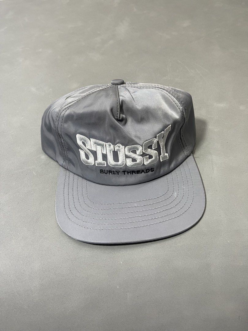Stussy (Category: Caps & Hats) located in Manila. Submitted by mine2ownit (Listing ID 1467287372, Image 3). Description: - Color: Grey - Design: Embroidered white "text above the back strap - Closure: Adjustable plastic strap for a custom fit - Brim: Curved brim with a black underbrim - Size: Standard adult size (fits most head shapes) - Condition: Clean fabric structure, ready to wear.