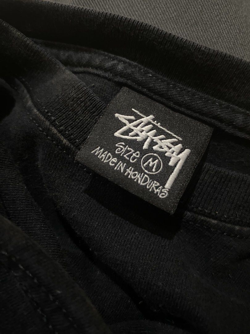 Stussy Black Tee with White Logo (Category: Tshirts & Polo Shirts ) located in Ozamiz City. Submitted by hakdmxma (Listing ID 1467267008, Image 3). Description: - Brand: Stüssy - Color: Black - Size: Medium (Standard fit) - Material: 100% Cotton (Made in Honduras) - Design: Small logo on chest, large graphic print on the back - Neckline: Crew neck - Condition: Pre-loved with light fabric fading and minor back print cracking from washing.