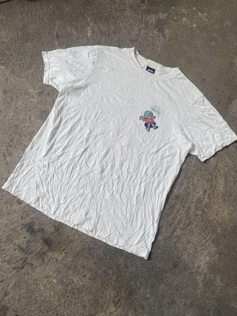 Stussy Graphic Tee White Size M (Category: Tshirts & Polo Shirts ) located in General Santos City (Dadiangas). Submitted by killcloa2368358 (Listing ID 1467340183, Image 1). Description: - Brand: Stussy - Color: White - Size: Medium - Material: 100% Cotton (Made in Guatemala) - Fit: Standard short sleeve crewneck - Design: Small left-chest logo and large alien doll back graphic with signature branding - Condition: Includes original neck tag and c