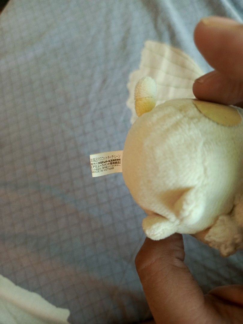 Sumikko Gurashi plush keychain with yellow bath cap (Category: Plushies & Soft Toys) located in Malasiqui. Submitted by shop.bea (Listing ID 1467206457, Image 2). Description: - Super soft white plush character holding a cute sponge - Features a bright yellow bath cap detail - Equipped with a ball chain for easy hanging on bags or keys - Includes original fabric tag with Japanese text (Made in Vietnam) - Fluffy texture, perfect as a bag charm or 