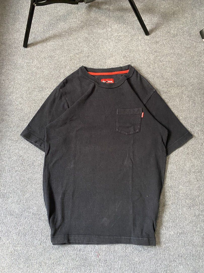 Supreme Black Pocket Tee (Category: Tshirts & Polo Shirts ) located in Maria Aurora. Submitted by mightypenguin.f7ca53 (Listing ID 1467273866, Image 1). Description: - Brand: Supreme - Color: Black with red inner collar detail - Features: Chest pocket and iconic streetwear design - Size: S (tag attached at neckline) - Condition: Slight fabric fading from wear; minor fraying visible on the brand label.