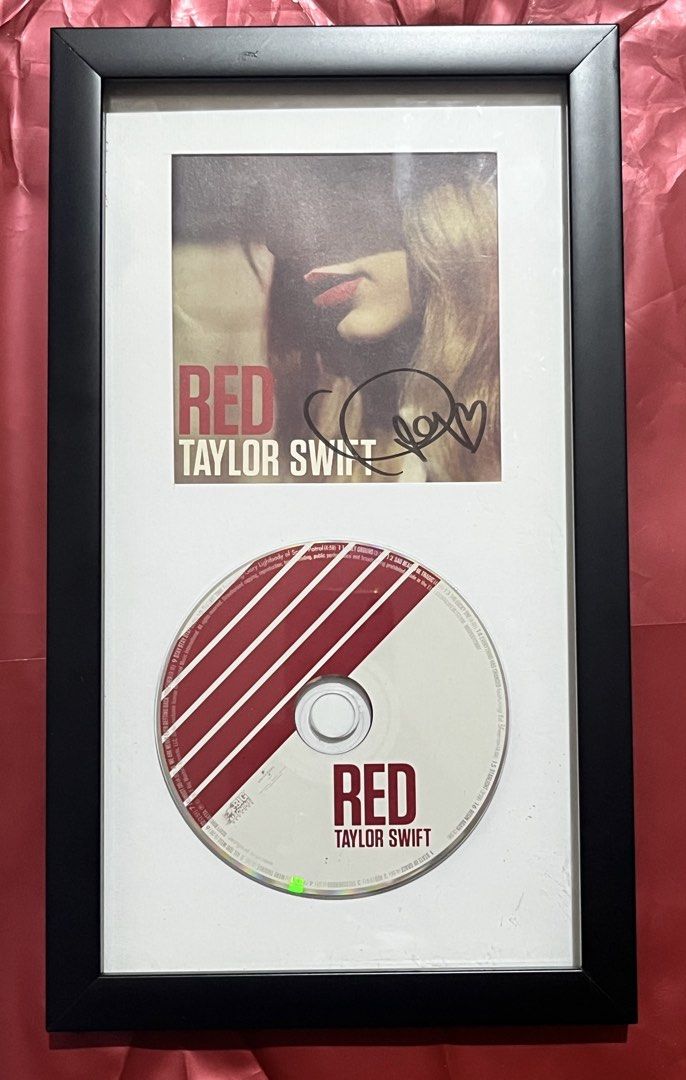 Taylor Swift signed RED OG Album (Category: Portable Music Players) located in Manila. Submitted by zealrabbit.2a0671 (Listing ID 1467359483, Image 1). Description: - Taylor Swift Red album ready-to-hang wall display - Sleek black frame with white matting - Includes booklet art featuring signature and heart doodle - Original CD included at the bottom - Perfect addition for any fan's collection.