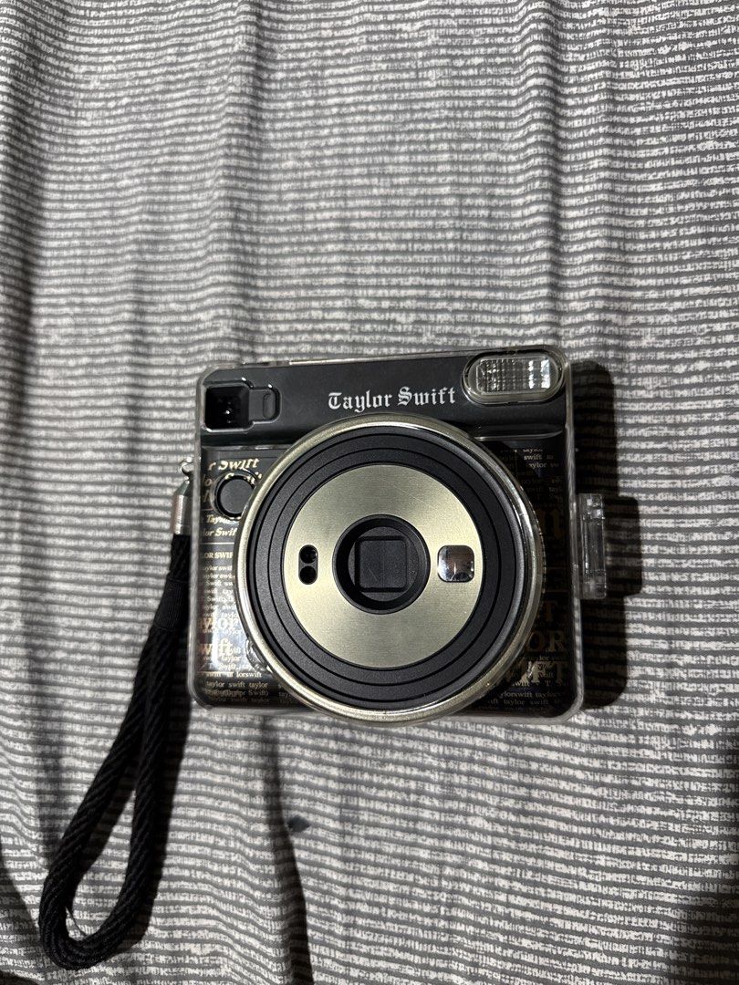 Taylor Swift Sq4 Reputation instax Camera (Category: Cameras) located in Manila. Submitted by sayelolo18 (Listing ID 1467279704, Image 1). Description: Item is fully working minor scratches only no issues at all - Authentic Taylor Swift Special Edition instant camera - Sleek black body featuring Taylor's printed signature on the back - Includes a clear protective plastic case and matching black wrist strap - Easy-to-use modes and built-in flash f