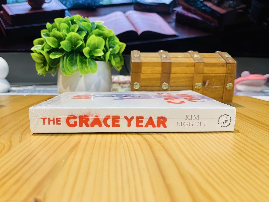 The Grace Year by Kim Liggett (Category: Storybooks) located in Makati City. Submitted by pagesandplay (Listing ID 1467318864, Image 2). Description: - Title: The Grace Year by Kim Liggett - Genre: Young Adult Dystopian Novel - Format: Paperback - Condition: Brand new, unread, and still shrink-wrapped - Cover: White with striking red and purple artwork.