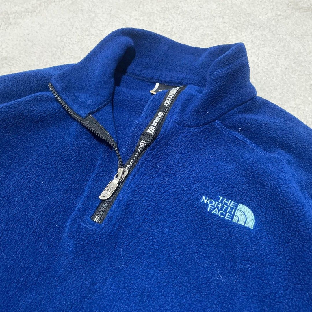 The North Face Blue Fleece Pullover Jacket (Category: Coats, Jackets and Outerwear) located in Taguig. Submitted by actualizeboutique (Listing ID 1467323841, Image 2). Description: - Brand: The North Face - Color: Deep Blue with Light Blue embroidered logo - Size: Men's Medium (Regular fit) - Material: 100% Polyester (Warm & soft) - Origin: Made in USA - Features: Half-zip collar with branded metal pull, two zippered hand pockets - Condition: Gre