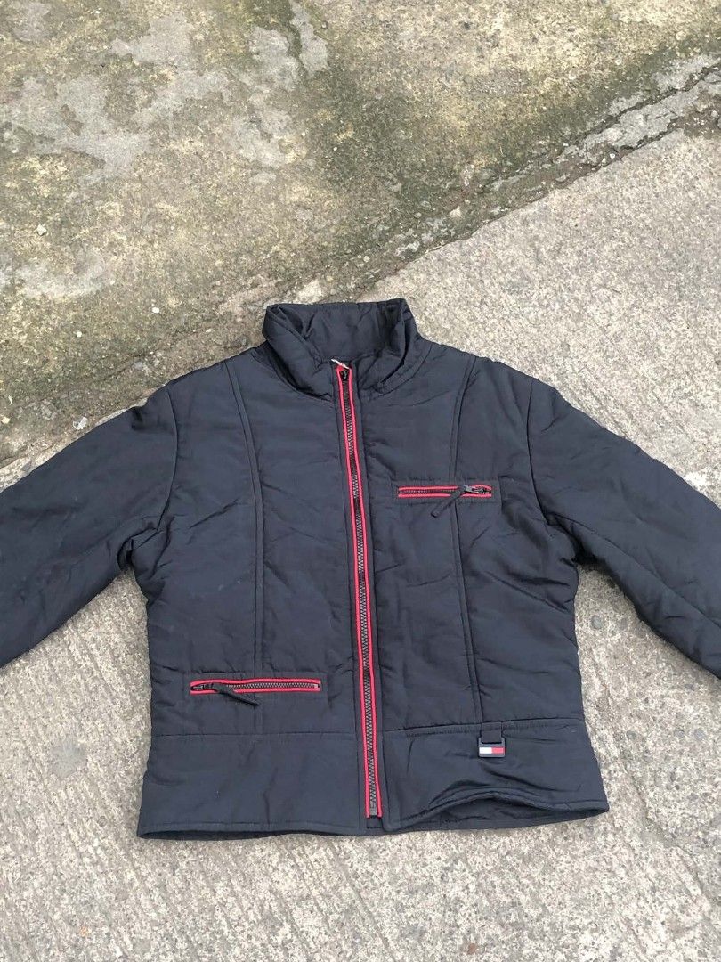 Tommy Jeans Black Puffer Jacket with Rainbow Back (Category: Coats, Jackets and Outerwear) located in Lucena. Submitted by ziboldawg (Listing ID 1467348042, Image 1). Description: - Brand: Tommy Jeans - Color: Black with vibrant rainbow vertical stripes on the back - Size: Medium (M) - Details: Red zippers on front pockets and main closure, custom 't' zipper pull, and signature Tommy flag logo on the front hem - Material: 100% nylon shell, 100% p