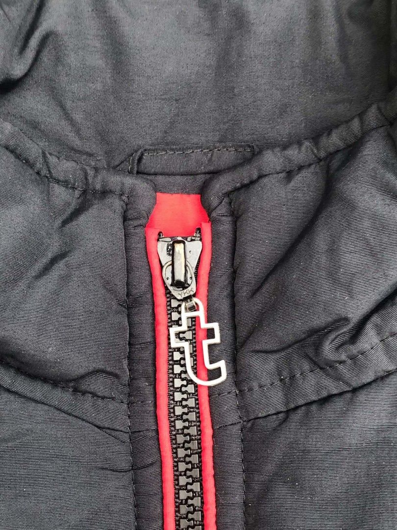 Tommy Jeans Black Puffer Jacket with Rainbow Back (Category: Coats, Jackets and Outerwear) located in Lucena. Submitted by ziboldawg (Listing ID 1467348042, Image 3). Description: - Brand: Tommy Jeans - Color: Black with vibrant rainbow vertical stripes on the back - Size: Medium (M) - Details: Red zippers on front pockets and main closure, custom 't' zipper pull, and signature Tommy flag logo on the front hem - Material: 100% nylon shell, 100% p