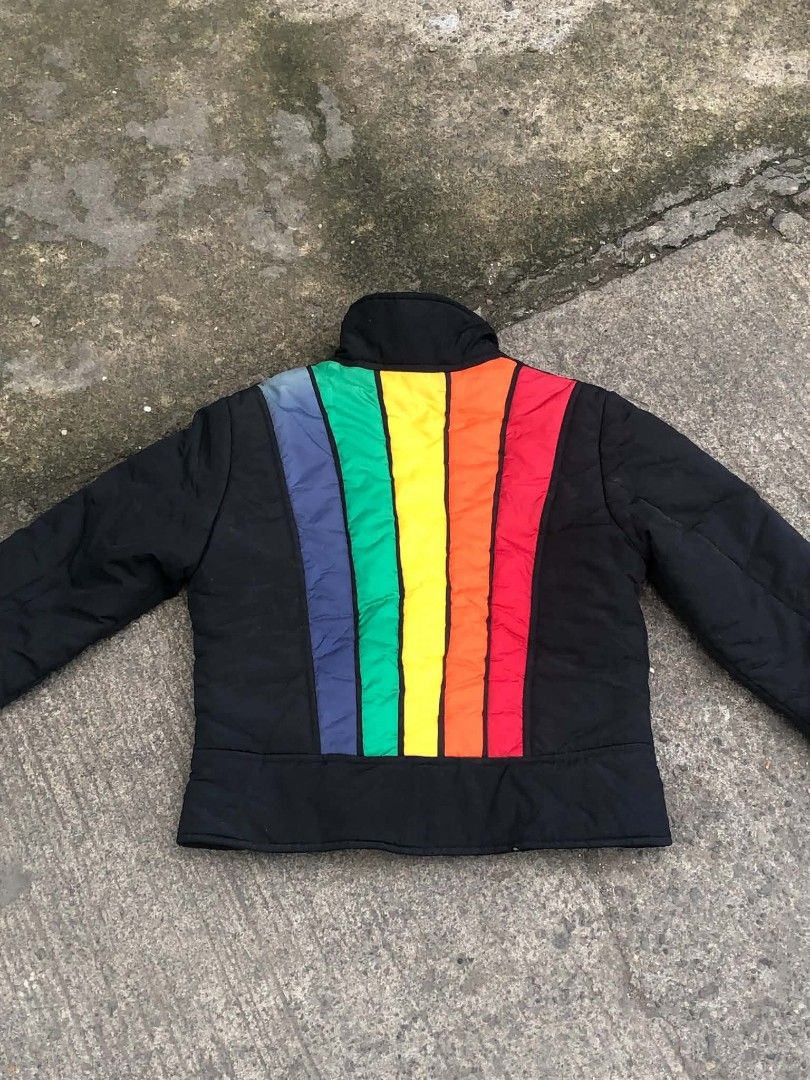 Tommy Jeans Black Puffer Jacket with Rainbow Back (Category: Coats, Jackets and Outerwear) located in Lucena. Submitted by ziboldawg (Listing ID 1467348042, Image 2). Description: - Brand: Tommy Jeans - Color: Black with vibrant rainbow vertical stripes on the back - Size: Medium (M) - Details: Red zippers on front pockets and main closure, custom 't' zipper pull, and signature Tommy flag logo on the front hem - Material: 100% nylon shell, 100% p