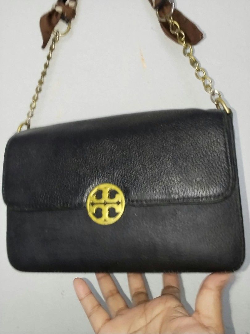 Tory Burch Black Leather Chain Shoulder Bag (Category: Shoulder Bags) located in Manila. Submitted by bagelyascollection (Listing ID 1467304205, Image 2). Description: - Authentic Tory Burch shoulder bag in classic black pebbled leather - Elegant gold-tone hardware and signature front logo clasp - Chic chain strap uniquely detailed with a brown patterned scarf tie - Vibrant textured green fabric interior lining - Compact, structured shape with a 