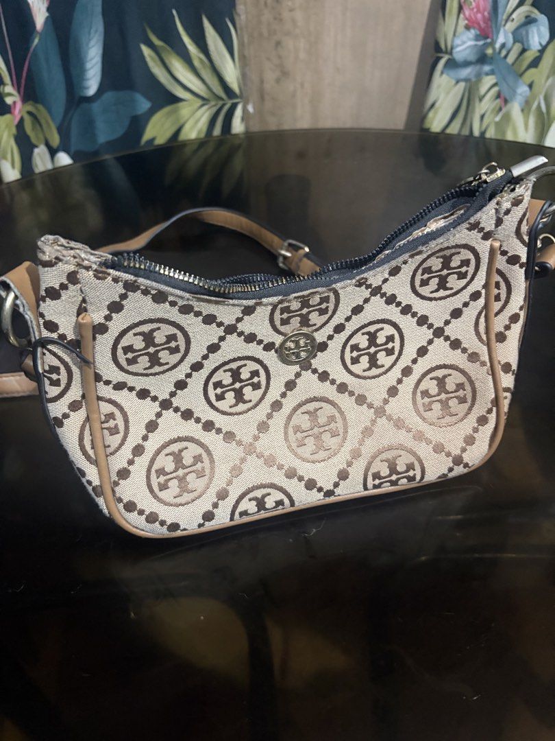 Tory Burch Monogram Print Canvas Shoulder Bag Brown (Category: Luxury Bags & Wallets) located in Manila. Submitted by mcllts (Listing ID 1467349106, Image 1). Description: - Tory Burch brown canvas shoulder bag with signature monogram print - Stylish tan leather trim and matching comfortable straps - Secure top zipper closure with branded hardware pulls - Fully lined interior compartment for your daily essentials - Handy exterior zippered pocket 