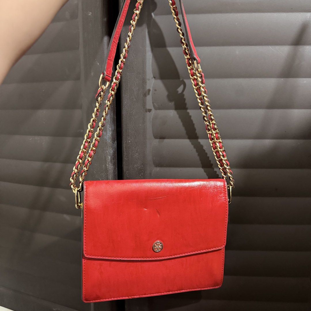 Tory Burch Red Leather Chain Crossbody Project Bag (Category: Luxury Bags & Wallets) located in Rizal. Submitted by lovegclothingph (Listing ID 1467313590, Image 1). Description: - Brand: Tory Burch - Color: Vibrant red with gold hardware - Material: Genuine leather with fabric lining - Design: Structured multi-compartment interior, magnetic snap closure, and small gold logo emblem - Strap: Double chain strap interwoven with matching red leather 