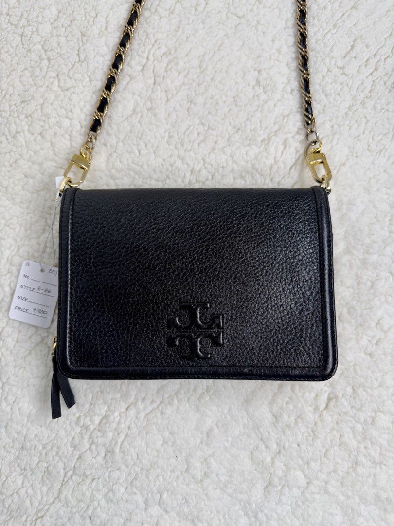 TORY BURCH Thea Flat Wallet Sling Leather Bag (Category: Luxury Bags & Wallets) located in Quezon City. Submitted by madame_bagelia_collection (Listing ID 1467295000, Image 2). Description: 🔸Authentic 💯 🔸Preloved 🔸Rank AB- Good condition, w/ signs of use. 🔸Slight fading on chain strap. 🔸Genuine leather 🔸Gold color hardwares 🔸Flap, magnetic button & zipper closure 🔸YKK zipper 🔸10 card slots 🔸Detachable chain strap 🔸Small size 🔸Dimensi
