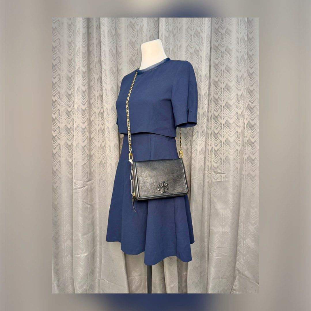 TORY BURCH Thea Flat Wallet Sling Leather Bag (Category: Luxury Bags & Wallets) located in Quezon City. Submitted by madame_bagelia_collection (Listing ID 1467295000, Image 1). Description: 🔸Authentic 💯 🔸Preloved 🔸Rank AB- Good condition, w/ signs of use. 🔸Slight fading on chain strap. 🔸Genuine leather 🔸Gold color hardwares 🔸Flap, magnetic button & zipper closure 🔸YKK zipper 🔸10 card slots 🔸Detachable chain strap 🔸Small size 🔸Dimensi