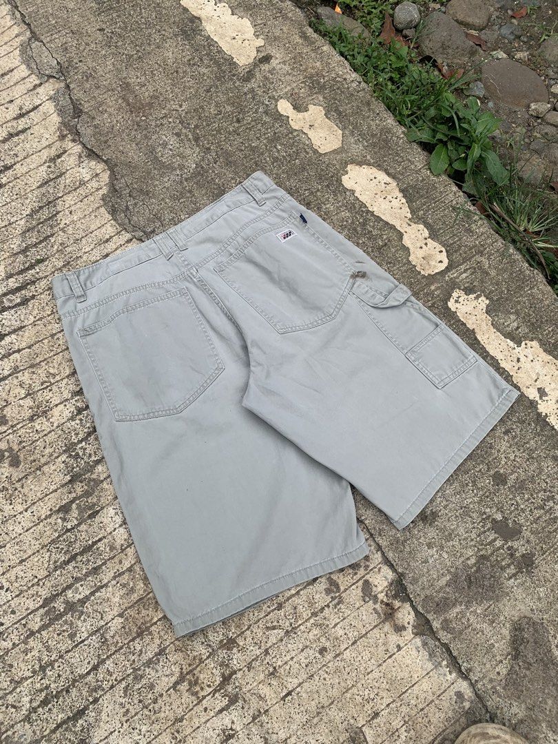 Towman2002 Grey Cargo Shorts Size 32 (Category: Shorts) located in Manila. Submitted by findusthrift (Listing ID 1467176623, Image 3). Description: - Brand: Towman2002 - Color: Grey - Material: Durable cotton twill fabric - Style: Classic carpenter style with hammer loop and tool pocket details - Closure: Button fly with branded waist label - Condition: Some stains on the front left leg area - Best for: Casual wear or outdoor work.